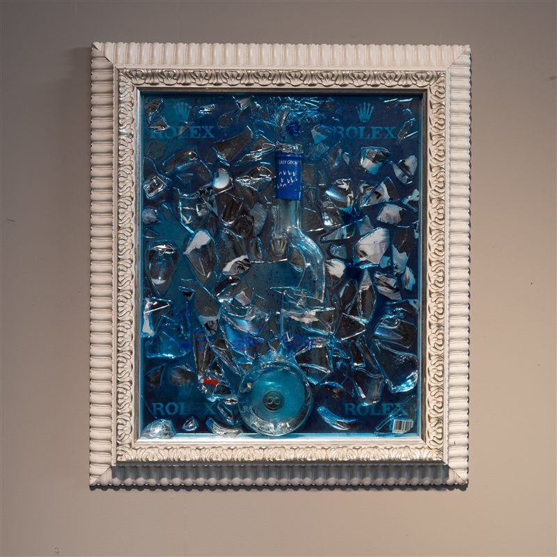 Cornice bianca con frammenti di Grey Goose su resina blu
